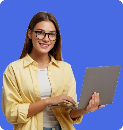 Uśmiechnięta młoda kobieta w okularach trzyma laptop i pracuje na stojąco na jednolitym tle